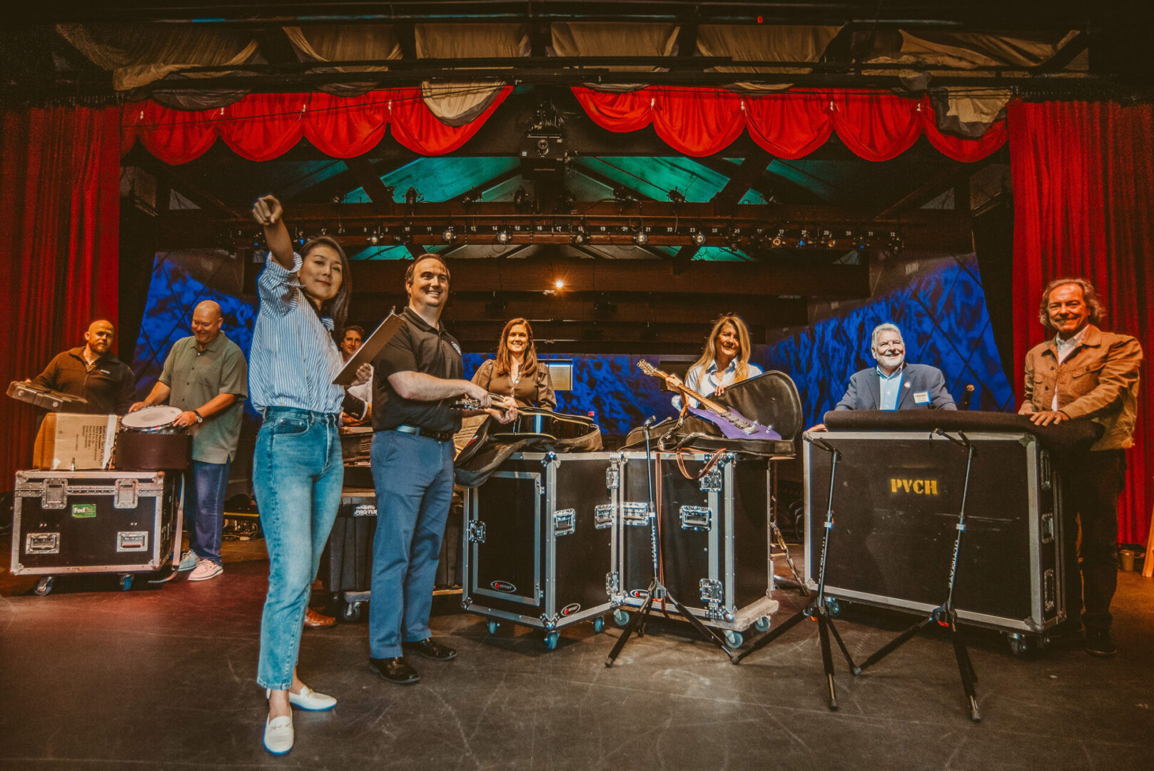 A group of people standing around some instruments.